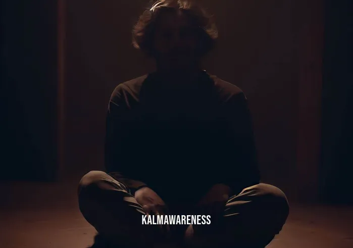 chakra healing meditation and guided visualization _ Image: A dimly lit room with a person sitting cross-legged, looking stressed and anxious. Image description: In a dimly lit room, a person sits cross-legged, their face marked by stress and anxiety.