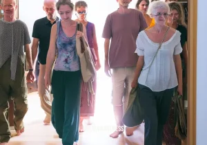 sebene selassie meditation _ Image: A group of individuals leaving the meditation hall with smiles on their faces, now equipped with the tools to navigate life's challenges with mindfulness.Image description: Exiting the meditation hall, participants wear contented smiles, having discovered a path to inner harmony and resolution in their daily lives.